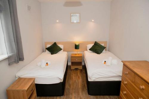 two twin beds in a room with a night stand at City Centre Gem in Galway