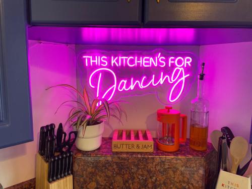 a neon sign that says this kitchen is for dancing at Escape to the Mountain in Halkyn