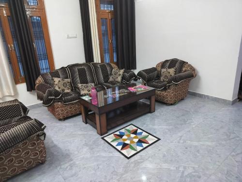 a living room with two couches and a coffee table at Hari Om Homestay in Faizābād