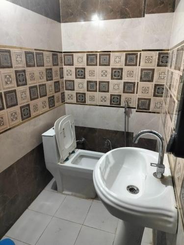 a bathroom with a toilet and a sink at Hari Om Homestay in Faizābād
