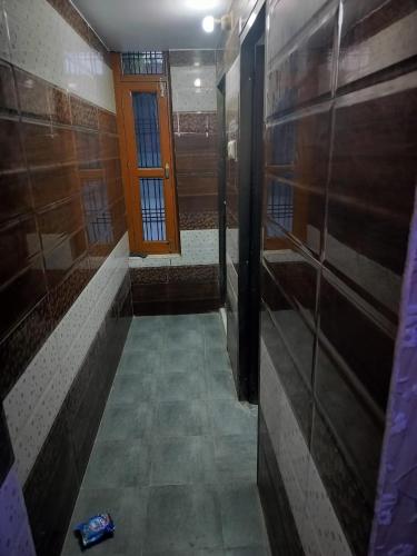 a bathroom with a walk in shower and a door at Hari Om Homestay in Faizābād