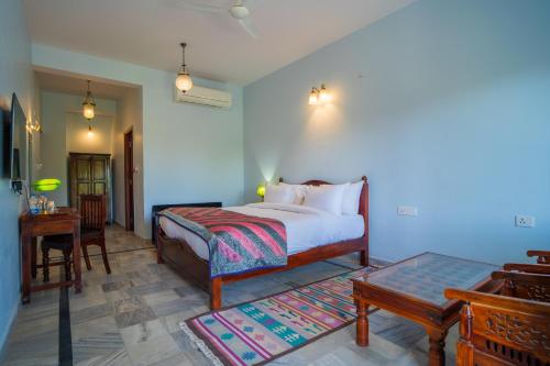 a bedroom with a bed and a table and a desk at Koolwal Kothi Zinc Journey by The Fern, Nawalgarh, Rajasthan in Nawalgarh
