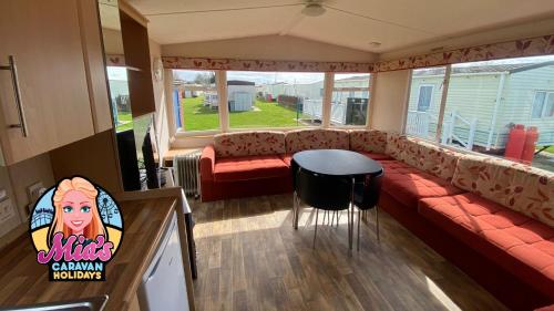 a living room with a couch and a table at The Cosalt Torbay Caravan in Ingoldmells