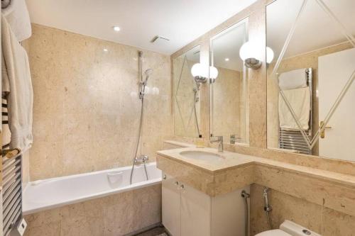 une salle de bain avec un lavabo, un miroir et une baignoire dans l'établissement Cannes: Appartement centre 2 chambres, à Cannes