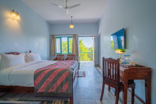 a bedroom with a bed and a desk and a window at Koolwal Kothi Zinc Journey by The Fern, Nawalgarh, Rajasthan in Nawalgarh