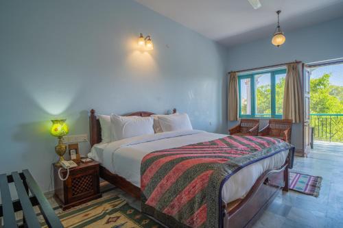 a bedroom with a bed and a large window at Koolwal Kothi Zinc Journey by The Fern, Nawalgarh, Rajasthan in Nawalgarh