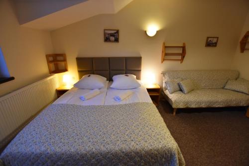 a hotel room with a bed and a couch at Sasanka Szczyrk przy Gondoli in Szczyrk