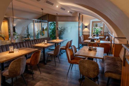 a dining room with wooden tables and chairs at Hotel Anker in Klosterneuburg