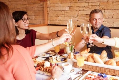 a group of people sitting around a table with wine glasses at Il centro in Petronell