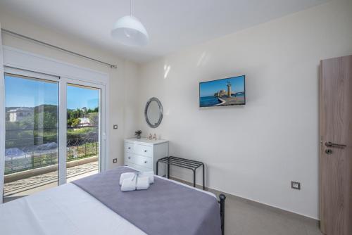 a white bedroom with a bed and a window at Nimarevi Apartment in Soroni