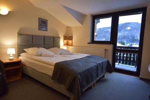 sypialnia z dużym łóżkiem i dużym oknem w obiekcie Sasanka Szczyrk przy Gondoli w Szczyrku
