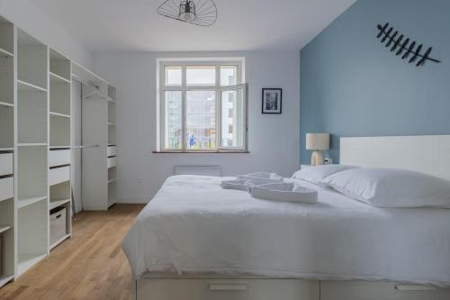 Un dormitorio blanco con una cama grande y una ventana. en Les arènes, Metz Centre-Gare-Muse , 4 pers, en Metz