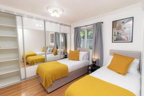 1 Schlafzimmer mit 2 Betten und gelber Bettwäsche in der Unterkunft K Suites - Rowley Road in Dudley