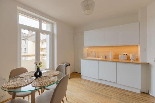 une cuisine et une salle à manger avec une table et des chaises dans l'établissement Les arènes, Metz Centre-Gare-Muse , 4 pers, à Metz