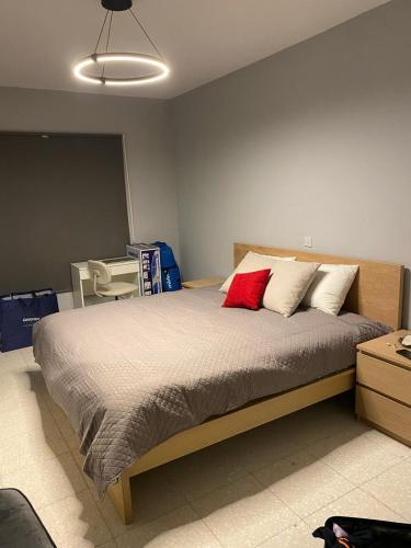 a bedroom with a bed with two red pillows at Newly renovated- Regina Gardens 1, Venus Beach 500 m, Sea&Sunsets view, license oo12075 in Paphos