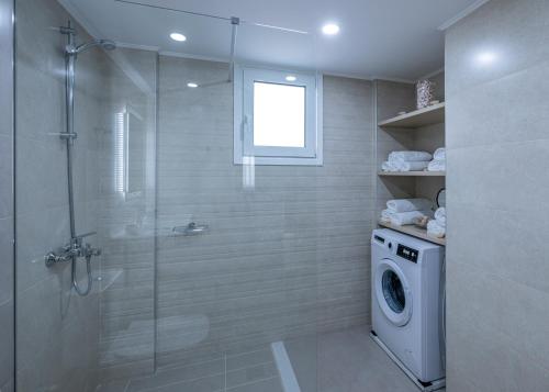 a bathroom with a shower and a washing machine at Nimarevi Apartment in Soroni