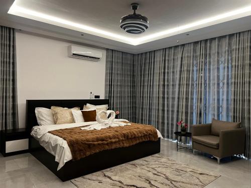 1 dormitorio con 1 cama grande y 1 silla en Airserenity Stay, en Kwedonu