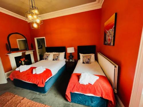 two beds in a room with red walls at horn and trumpet in Bewdley