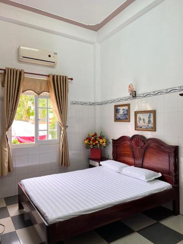 1 dormitorio con cama y ventana en Khách sạn Khoa Đạt en Di Linh