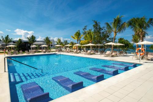 a swimming pool with lounge chairs and umbrellas at Riu Montego Bay - Adults Only - All Inclusive in Montego Bay