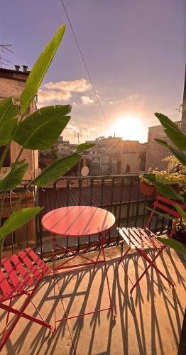 a table and chairs on a balcony with the sunset at Trevi over the top apartment in Rome