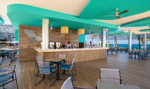 a restaurant with blue ceilings and tables and chairs at Riu Montego Bay - Adults Only - All Inclusive in Montego Bay