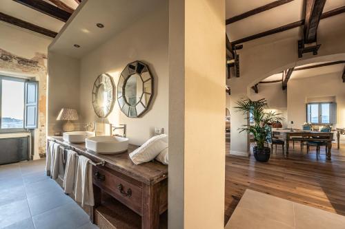 a bathroom with two sinks and a table in the background at Palazzo Boyl 1840 in Cagliari