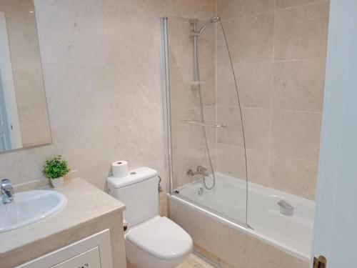a bathroom with a shower and a toilet and a sink at El Oasis de Roda Golf Apartment in San Javier