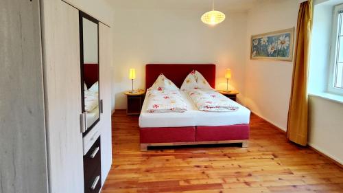 ein Schlafzimmer mit einem Bett mit Kissen darauf in der Unterkunft Ferienwohnung Stelzl in Sankt Johann im Saggautal