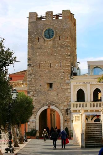 a large brick building with a clock tower at Casa Vacanze Etna Sunset in Giarre