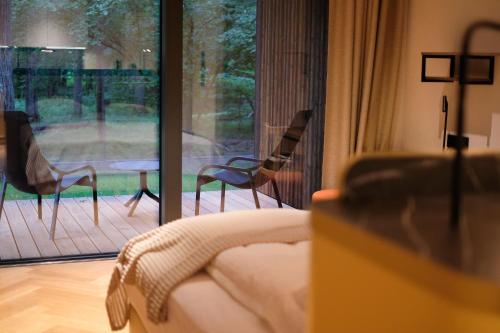 a living room with chairs and a sliding glass door at Enklawa Białowieska Forest & Spa in Hajnówka