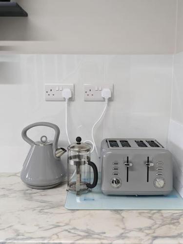a kitchen counter with a toaster and a tea kettle at Serenity Ballycastle in Ballycastle
