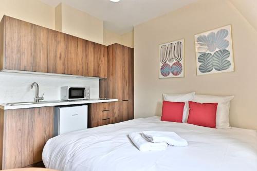 - une chambre avec un lit blanc, des oreillers rouges et un lavabo dans l'établissement Studio central Opéra Garnier - Paris, à Paris