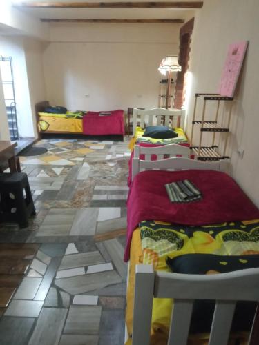 um quarto com 3 camas e piso em azulejo em SWEETHOSTEL em Tbilisi