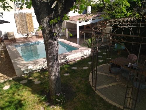 - une piscine avec un arbre dans la cour dans l'établissement Studio indépendant dans charmante bastide, à Mallemort