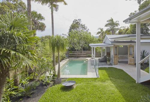 un patio trasero con piscina y una casa en Patrick Street Villa, en Avalon