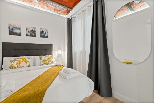 um quarto com uma cama e um espelho em Tendency Apartments 5 em Barcelona