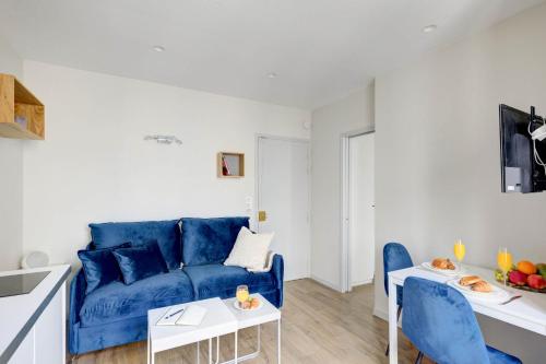 a living room with a blue couch and a table at Invalides & Eiffel Tower - CityApartmentStay in Paris