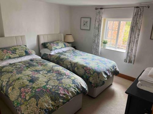 1 dormitorio con 2 camas y ventana en South Downs Cottage With Views, en Poynings