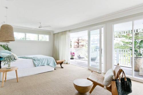- une chambre blanche avec un lit et un balcon dans l'établissement Freshwater Beach House, à Freshwater