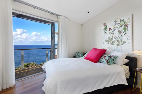 a bedroom with a bed with a view of the ocean at Curley Sunrise - Oceanfront in Curl Curl