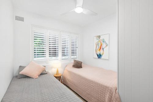 a bedroom with two beds and a window at Beachfront Magic Unbeatable Location in Sydney