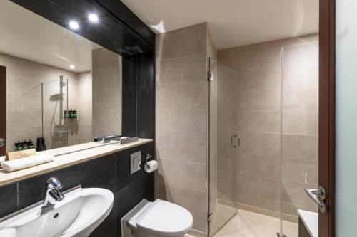 a bathroom with a toilet and a sink and a shower at Apex City of Edinburgh Hotel in Edinburgh