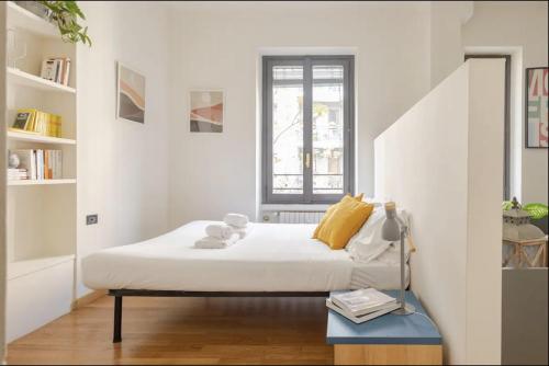 um quarto branco com uma cama e uma janela em • Grazioso appartamento tra City Life e San Siro •  em Milão