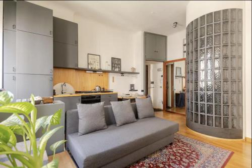 uma sala de estar com um sofá e uma cozinha em • Grazioso appartamento tra City Life e San Siro •  em Milão