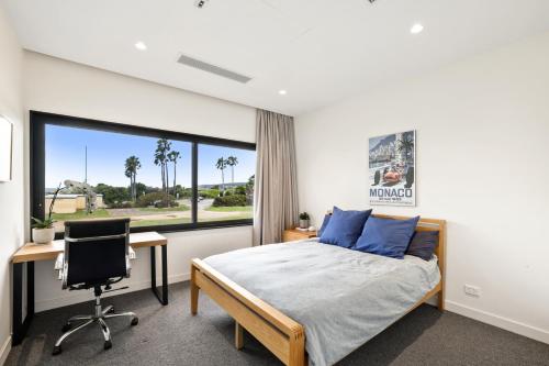a bedroom with a bed and a desk and a window at Modern Home on Freshwater Beach in Freshwater