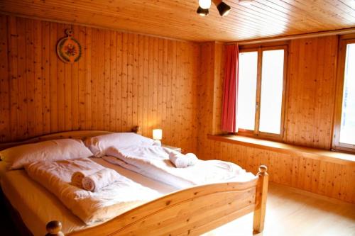 a bedroom with a bed in a wooden room at Alpine chalet apt w/parking and porch in Meiringen