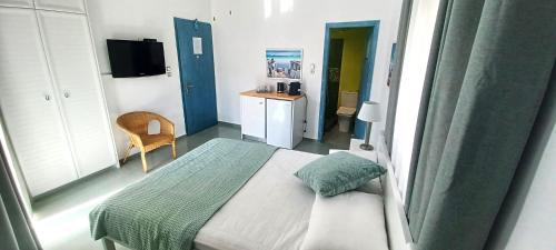 a small bedroom with a bed and a desk at Agora Center Building - Room 14 in Ios Chora