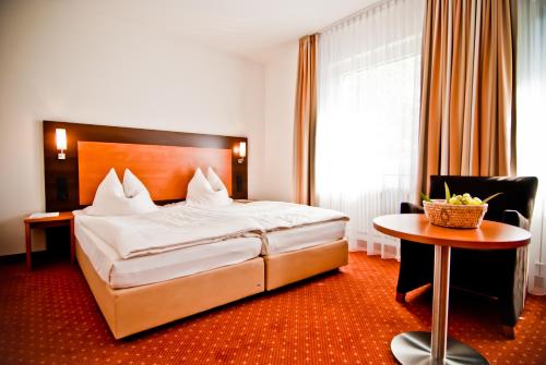 une chambre d'hôtel avec un lit et une table dans l'établissement ParkHotel Fulda, à Fulde
