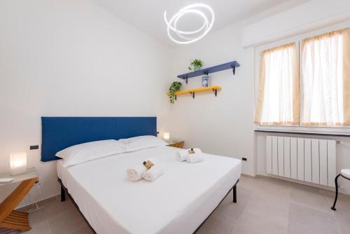 1 dormitorio con 1 cama blanca grande y cabecero azul en ALTIDO Blissful Flat for 6, Close To The Beach, en Santa Margherita Ligure